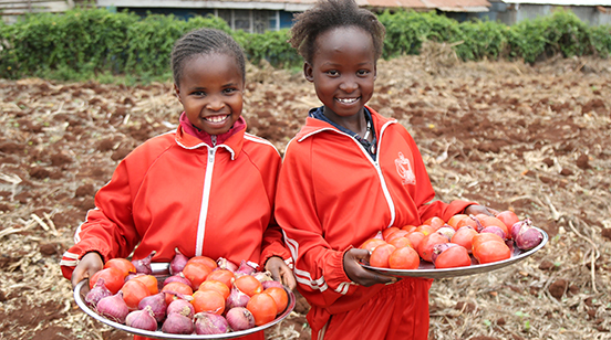Two children holding tomatoes