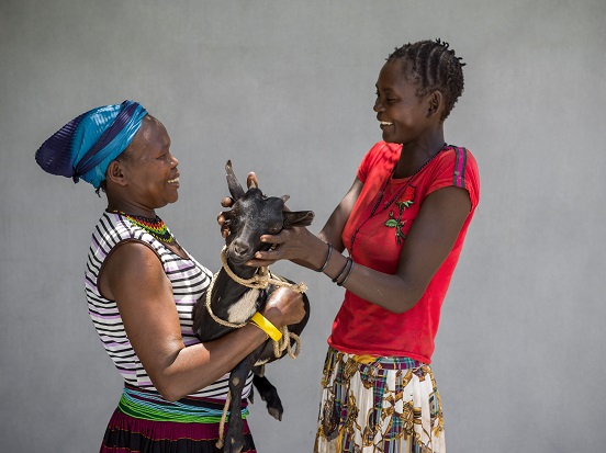 Theresa (left) giving a goat to Longole (right)