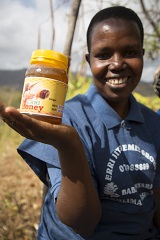 Joyce holding a jar of honey in Erri village, Tanzania.