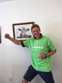 Fundraiser stands next to a picture of a cow