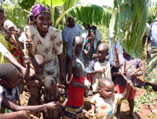 Celine with local children showing the new cassava planting material.